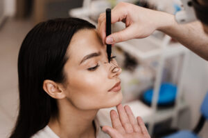 ENT doctor is drawing mark up lines on nose before rhinoplasty surgery. Rhinoplasty markup. Rhinoplasty is reshaping nose surgery for change appearance of the nose and improve breathing.